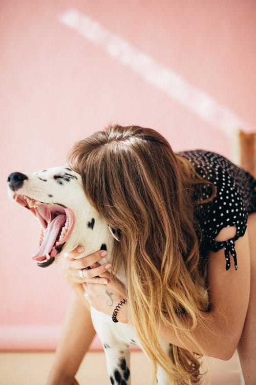 A woman hugging her Dalmatian