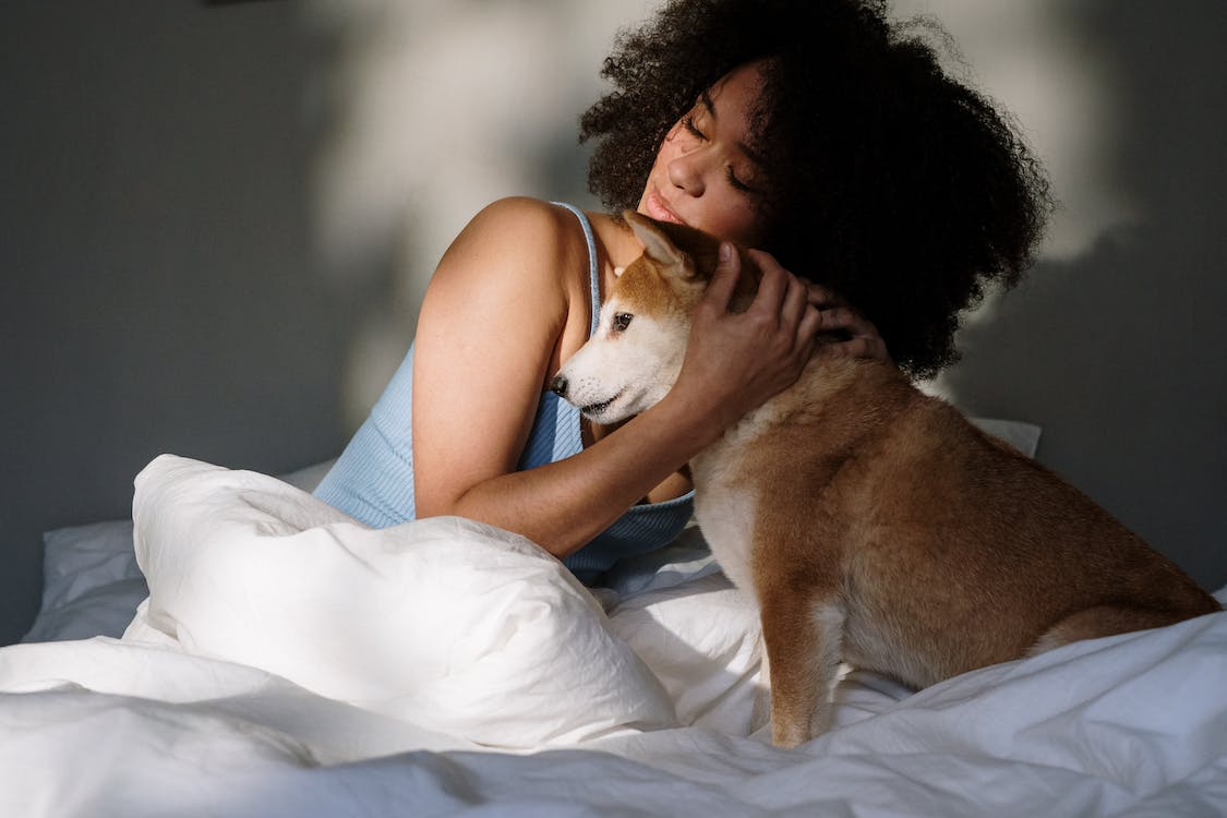 a woman in a bedroom with her dog
