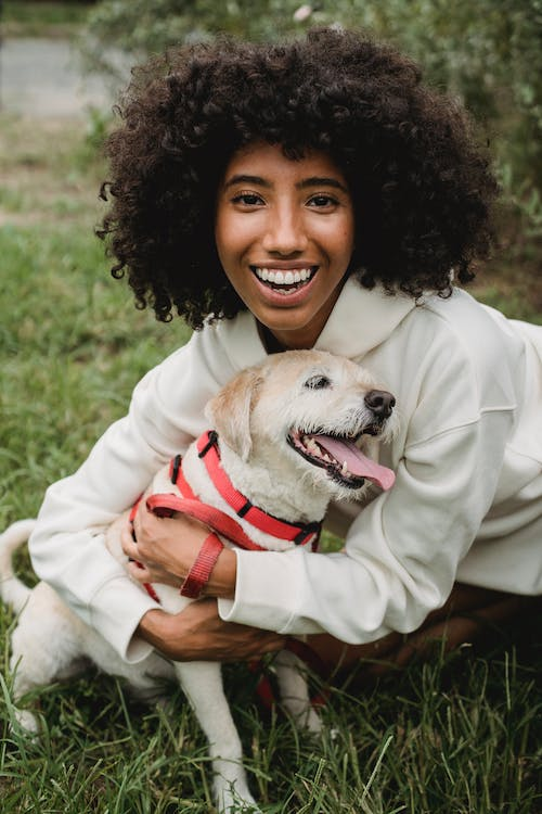 A smiling woman embracing her dog