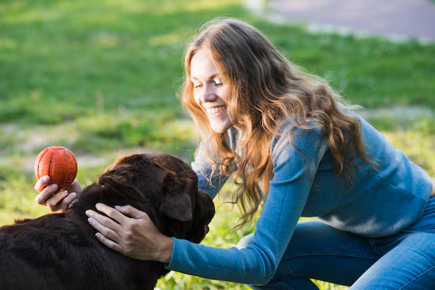 A woman playing with a dog