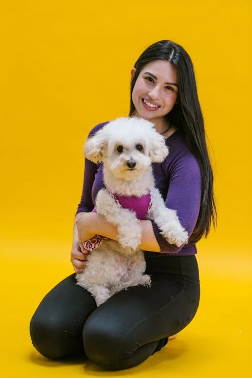 A person with a small white dog